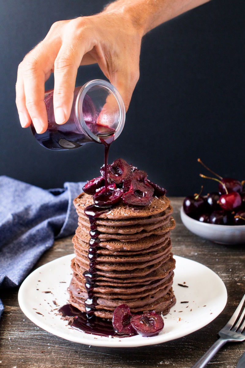 vegan chocolate pancakes with cherries pouring syrup