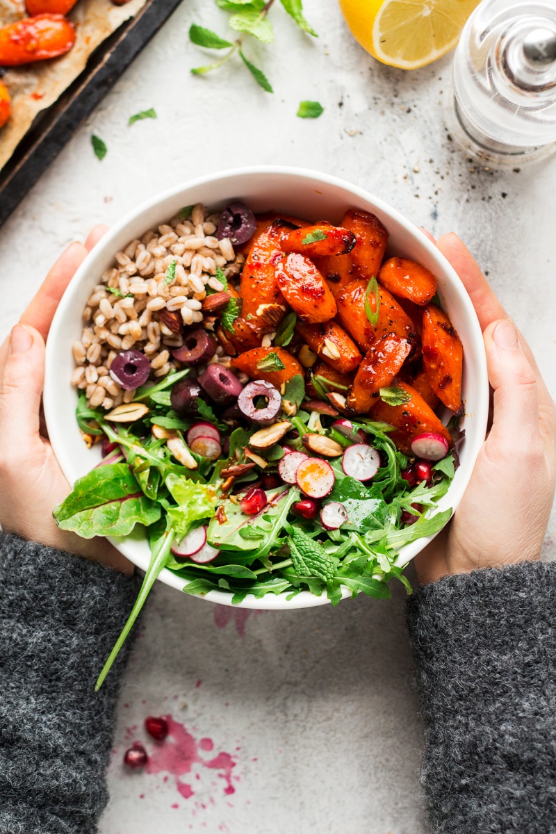 winter vegan bowl roasted carrots hands